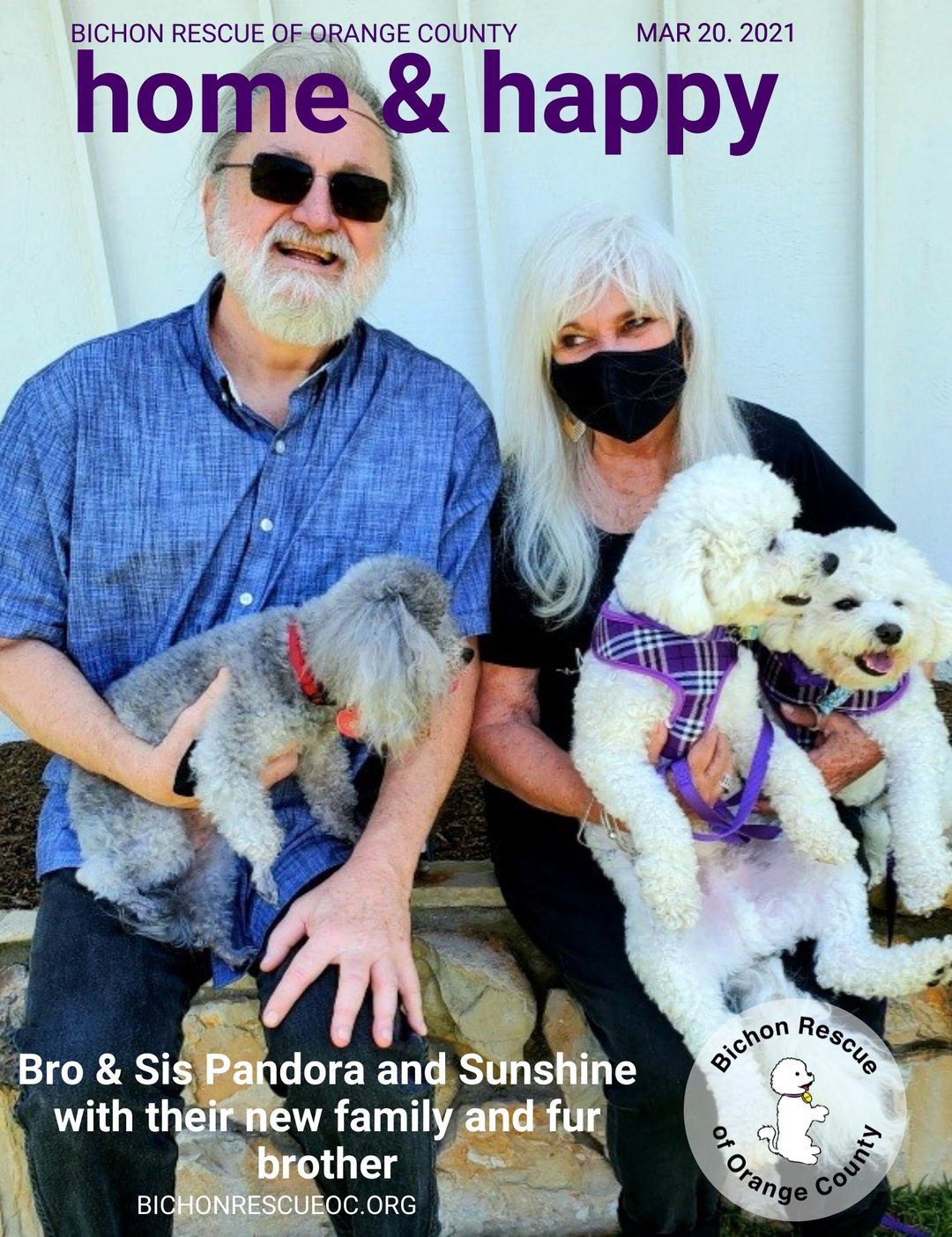 Couple with two dogs, smiling outdoors.